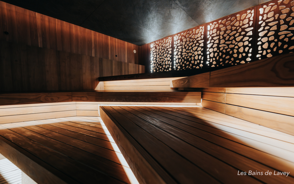 Modular sauna interior at Les Bains de Lavey with handcrafted wooden benches and warm integrated lighting